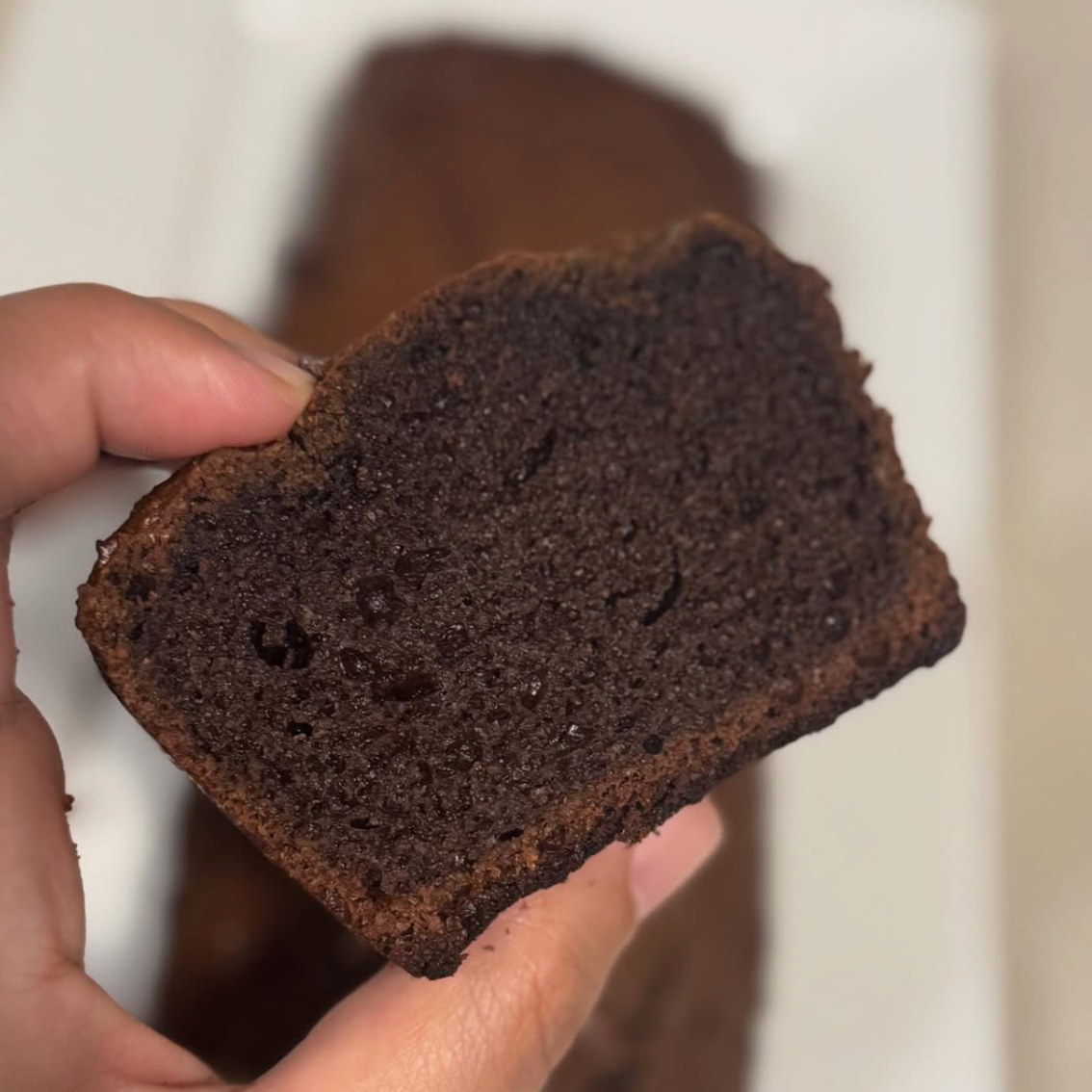 Cake au chocolat sans gluten Thermomix sur une table de goûter avec une tranche posée dans l’assiette